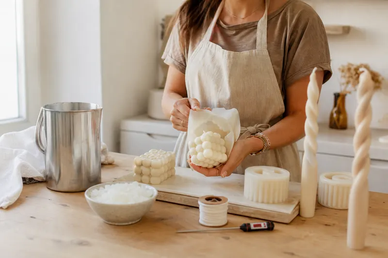 Démoulage d'une bougie bubble ivoire d'un moule en silicone sur un établi d'atelier
