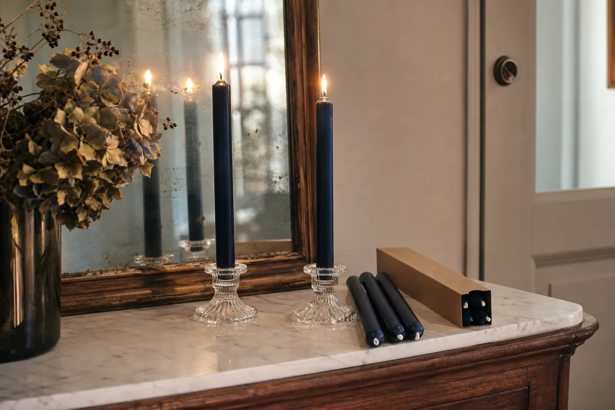 Bougies à tige bleu nuit de 18 cm allumées dans des bougeoirs en verre sur une console d'entrée
